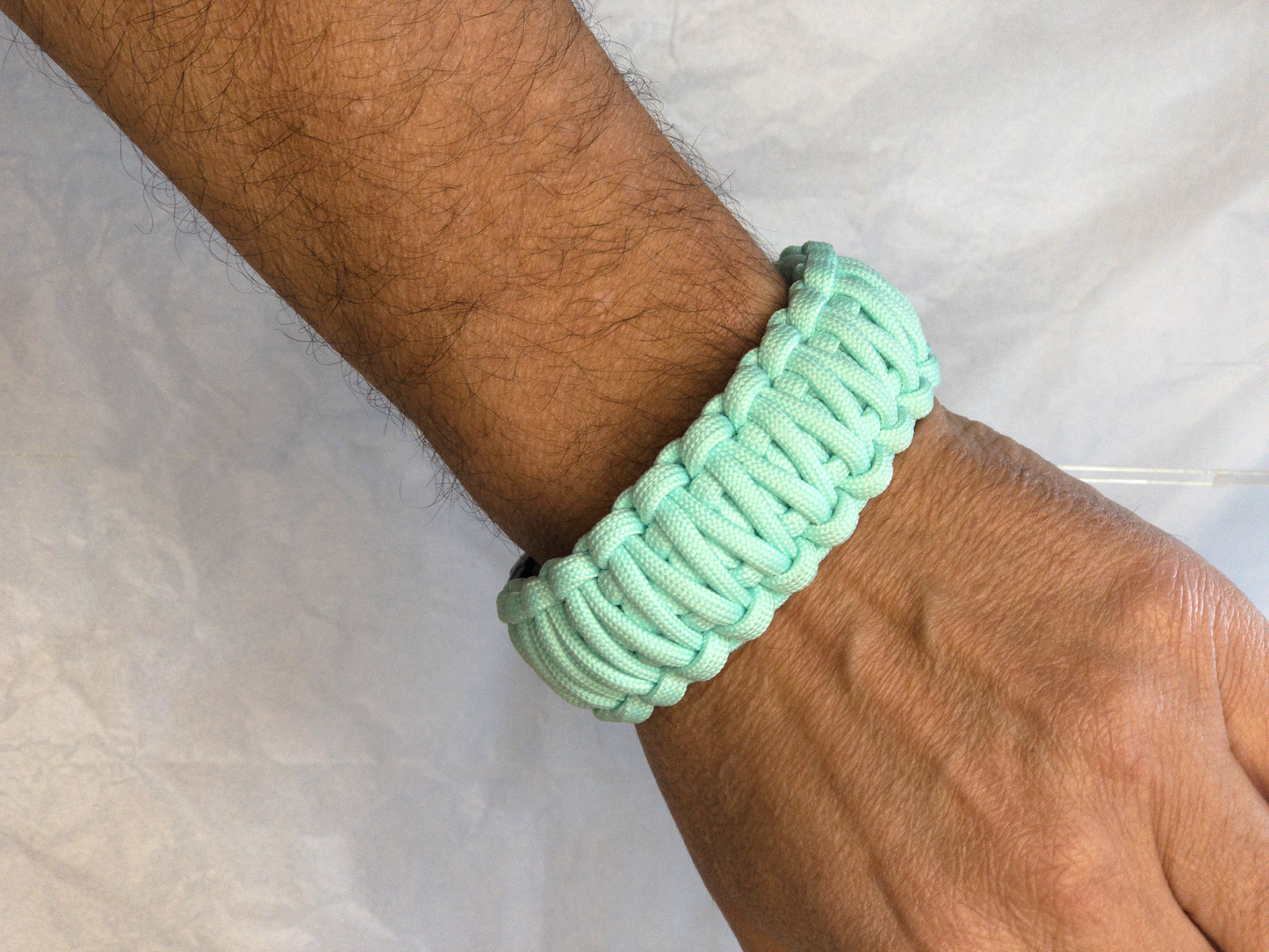 Pulsera Paracord COLOR TROPICANA BLUE con cierrre metalico de la colección Paracolor BGC BlakII. Imagen de la pulsera en la muñeca.